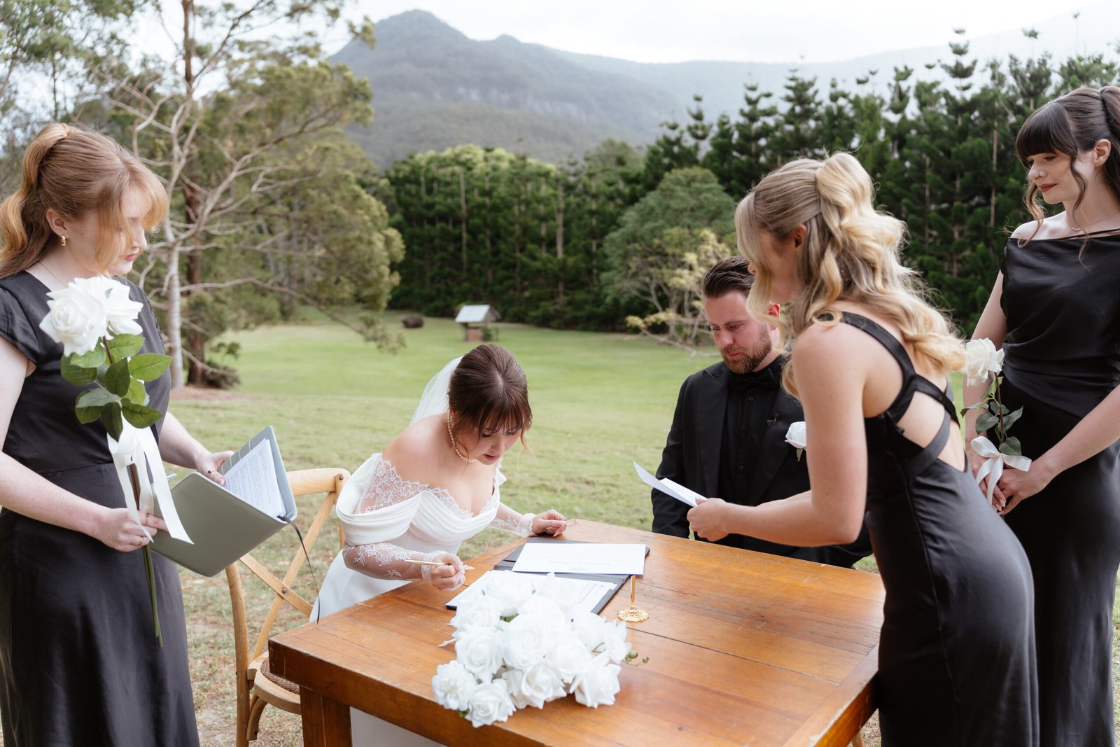 Gold Coast marriage celebrant Isabella with couple signing wedding documents