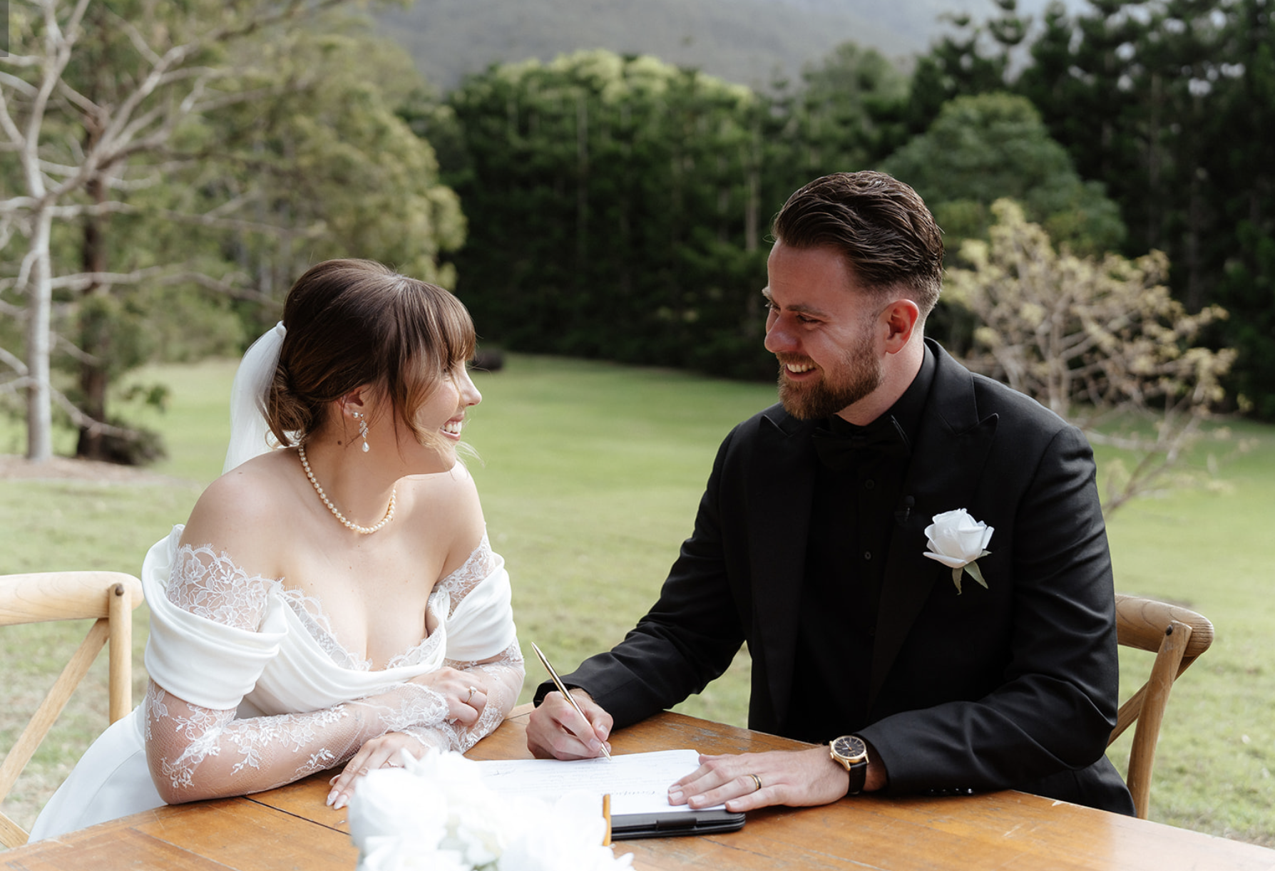 Couple smiling while signing ceremony paperwork